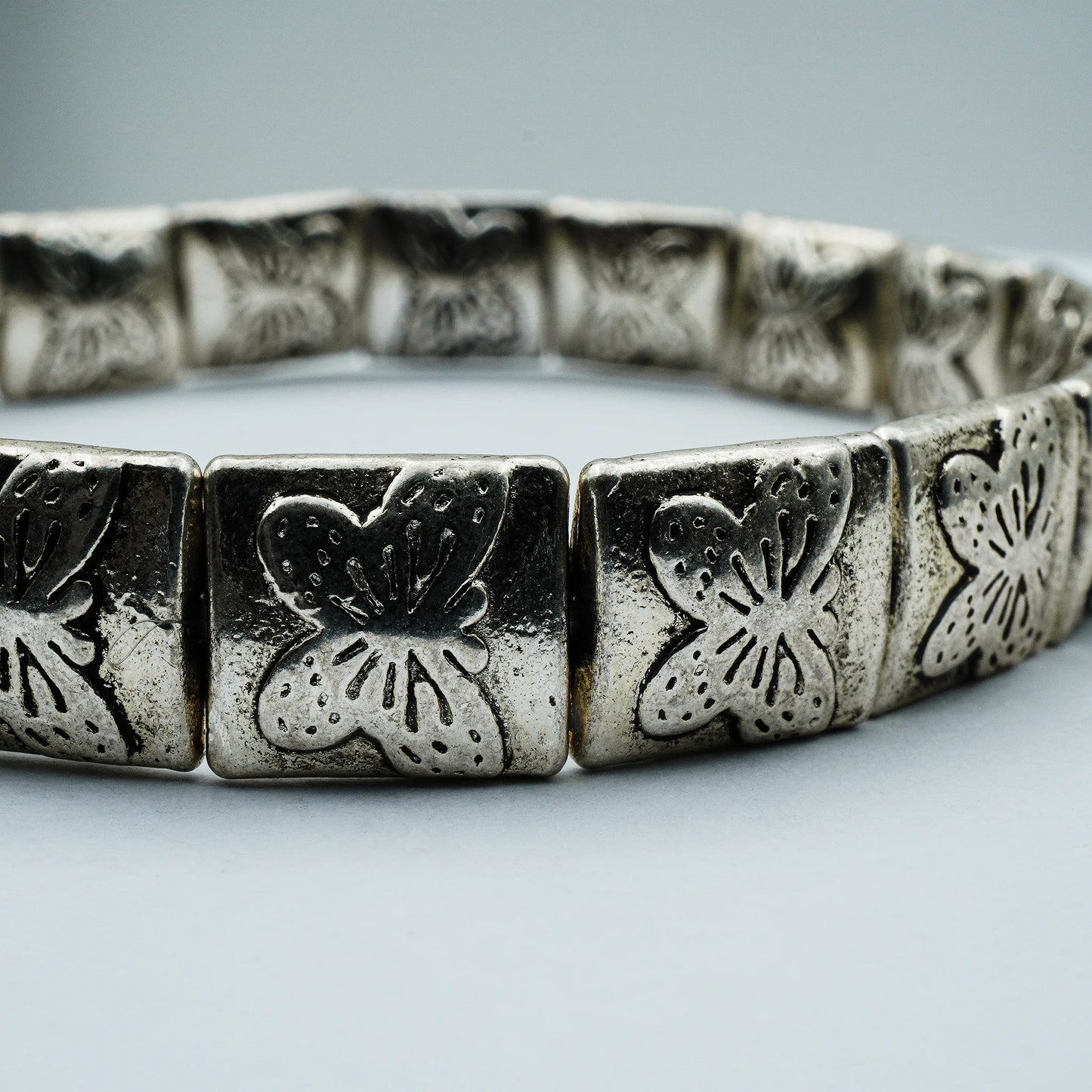 Close-up of handmade silver-plated bracelet with engraved botanical beads from the Silver Soul Collection.
