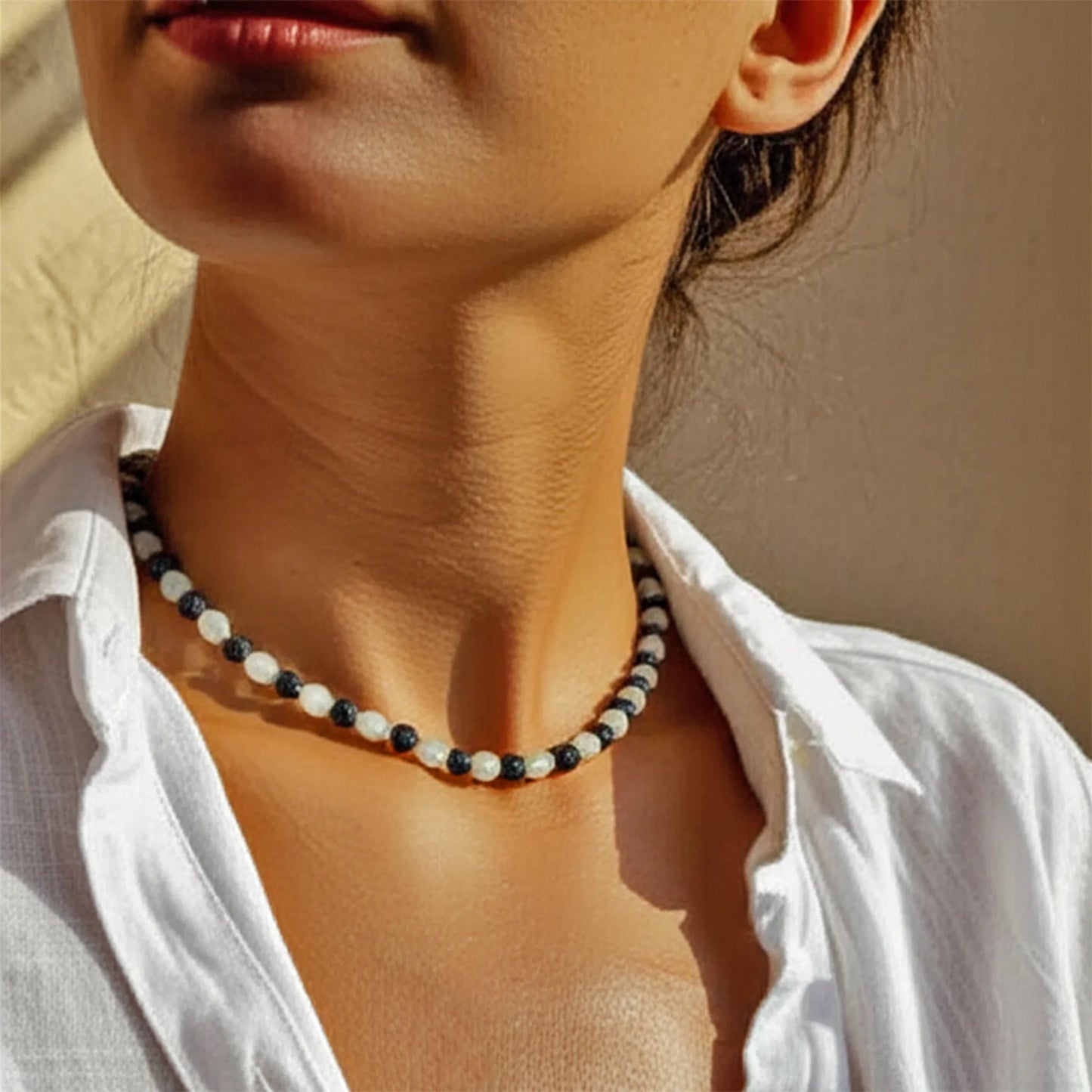 Lifestyle image of a woman wearing the Ocean Drift Sliding Bead Necklace featuring black lava and white seaglass beads — a coastal-inspired piece by Camins Fashion, handcrafted in Bali.