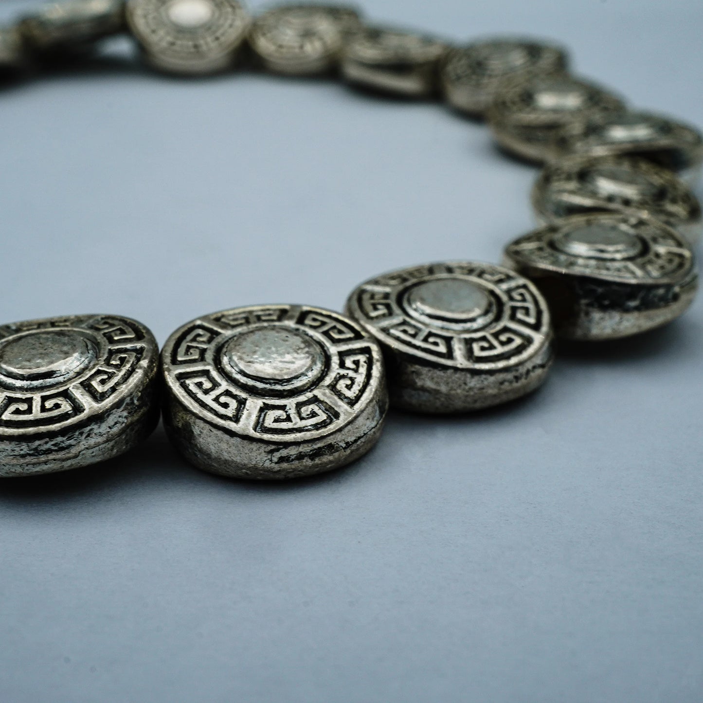 Close-up of the Ancient Coin Bracelet showcasing detailed vintage silver coin charms and boho elegance, handcrafted in Bali with artisanal precision.