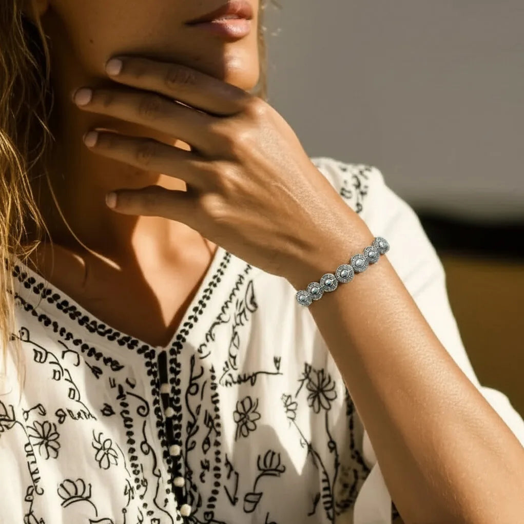Lifestyle image of the Ancient Coin Bracelet styled on the wrist, featuring vintage silver coin charms and boho elegance, handmade in Bali.