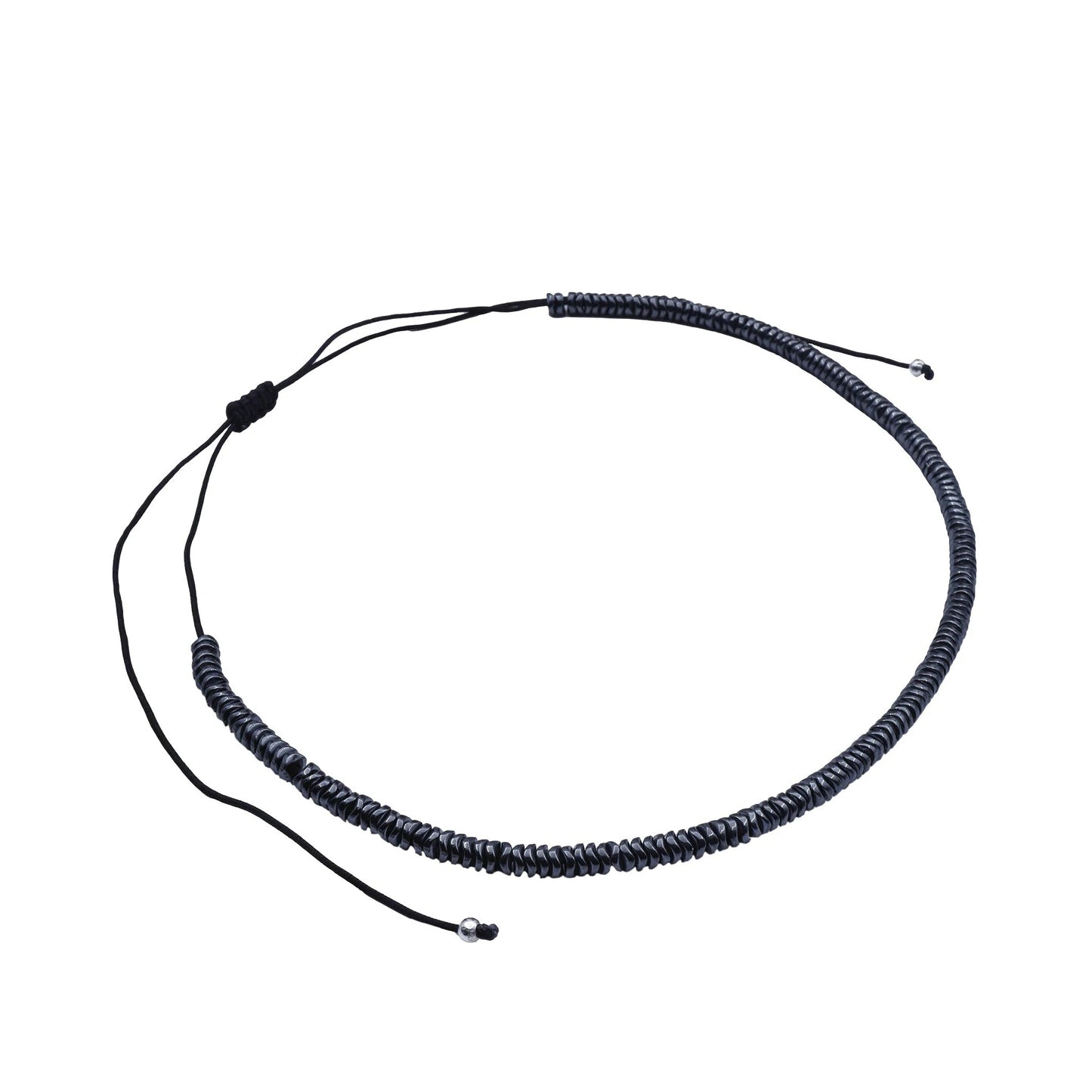 Side view of Midnight Hematite Sliding Knot Necklace by Camins, showcasing dark polished hematite beads and adjustable black silk cord—handmade in Bali with refined boho style.