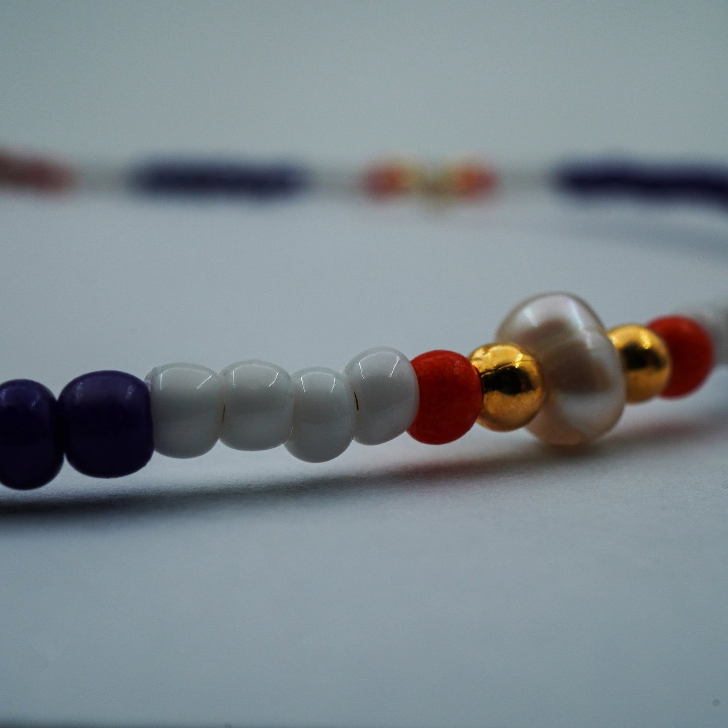 Close-up of the Seaside Harmony Beaded Anklet, highlighting the texture of natural shell beads and smooth glass accents, reflecting artisanal detail and handmade quality.