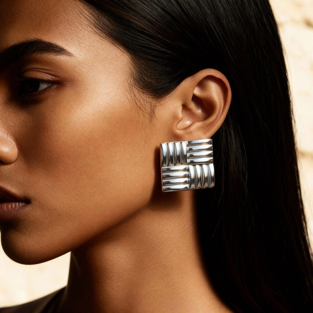 Model wearing golden drop earrings with hammered texture – artisanal handmade jewelry by Camins, Mediterranean boho chic style.