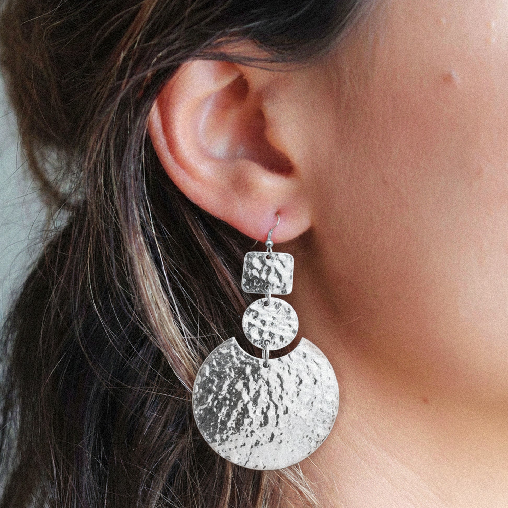 Handmade silver statement earrings with layered geometric discs – square, round, and crescent shapes – showcasing bold elegance and modern boho style.