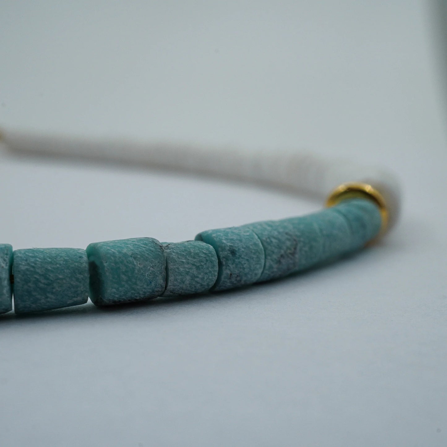 Close-up detail of the Coastal Harmony Anklet featuring smooth white puka shell beads with turquoise highlights. Shows texture, bead arrangement, and natural handmade beauty.