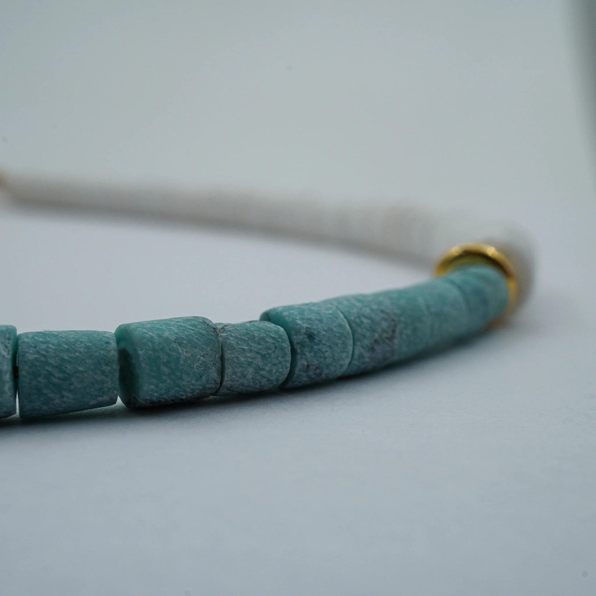 Close-up detail of the Coastal Harmony Anklet featuring smooth white puka shell beads with turquoise highlights. Shows texture, bead arrangement, and natural handmade beauty.