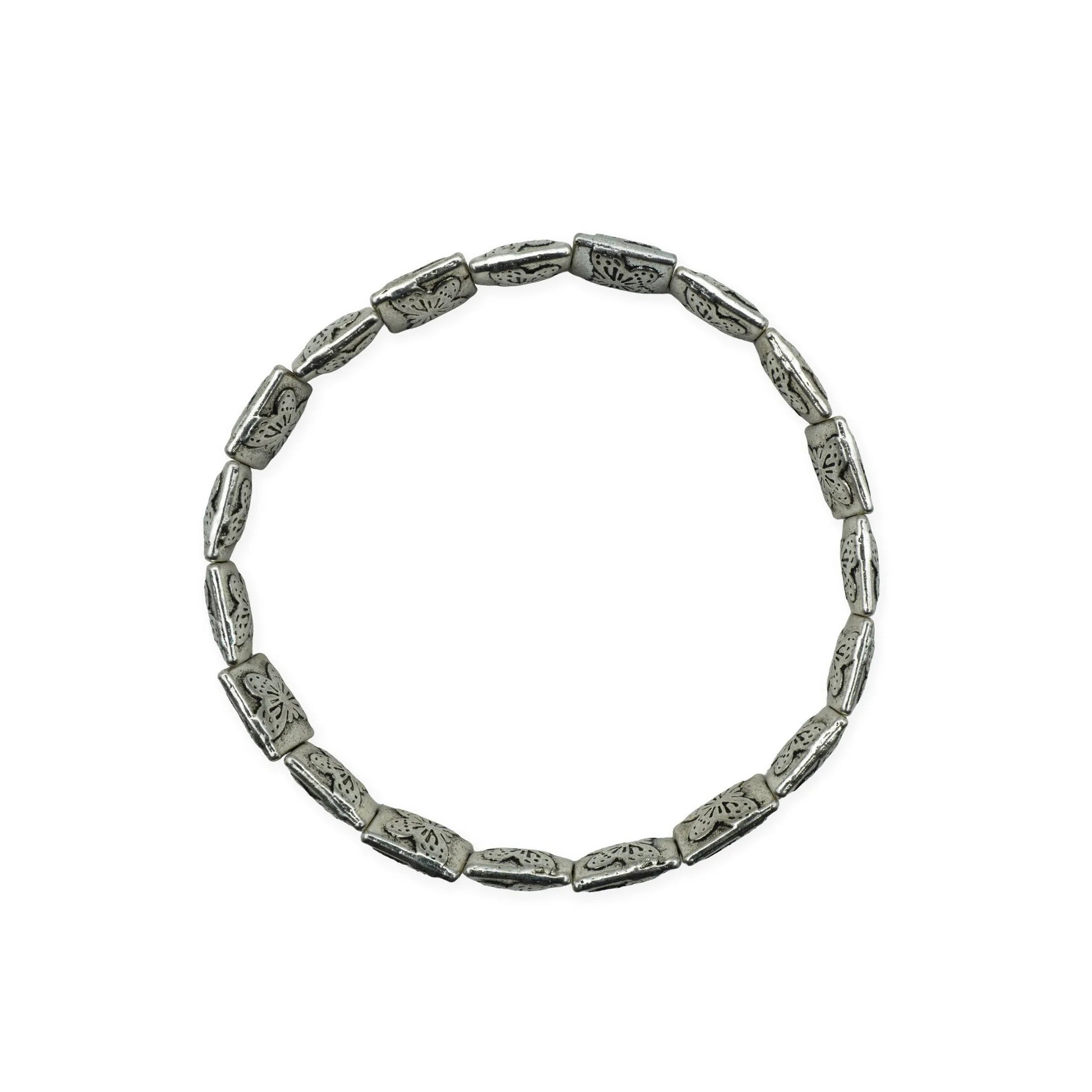 Scale view of botanical silver-plated bracelet showing engraved floral bead details.