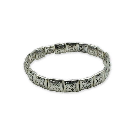 Side view of handmade botanical bracelet with silver-plated engraved beads.