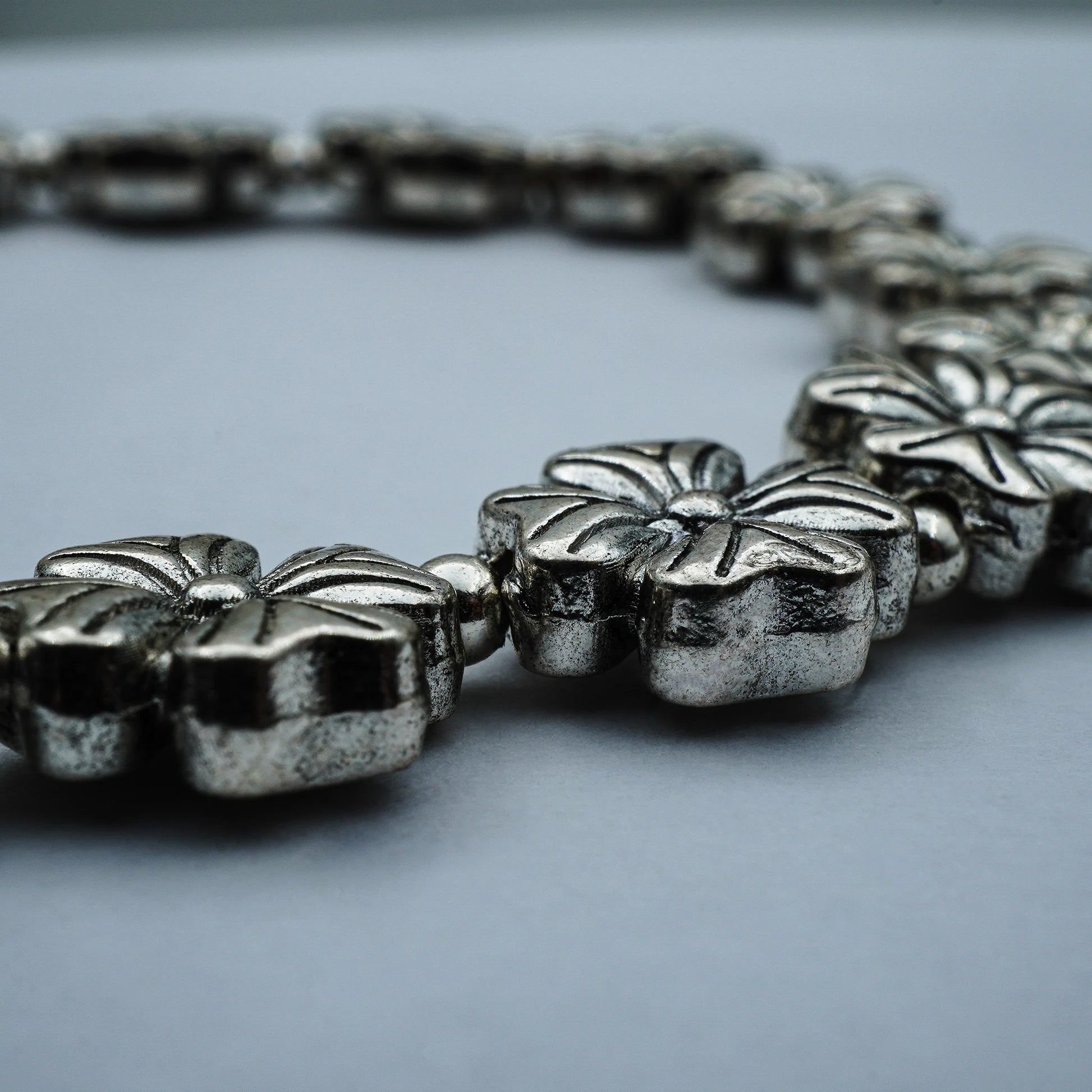 Close-up of the Blooming Blossom Bracelet highlighting intricate floral charms, golden accents, and artisanal handmade craftsmanship from Bali.