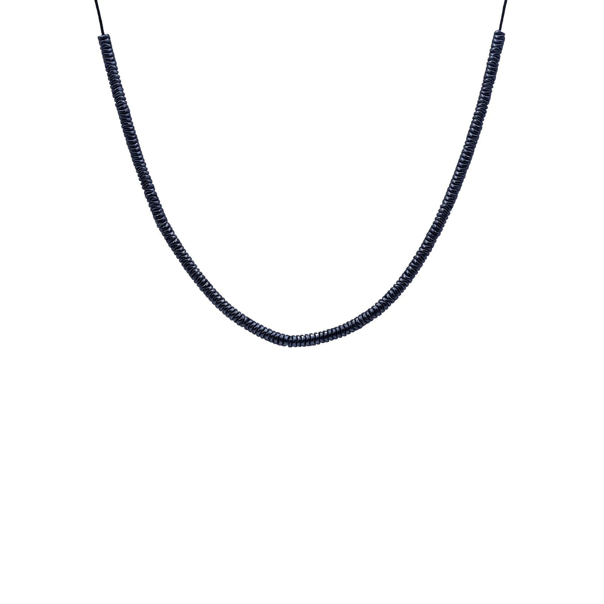Close-up of Midnight Hematite Sliding Knot Necklace by Camins, featuring dark hematite beads on a black silk cord—handmade in Bali with minimalist, boho-chic elegance.