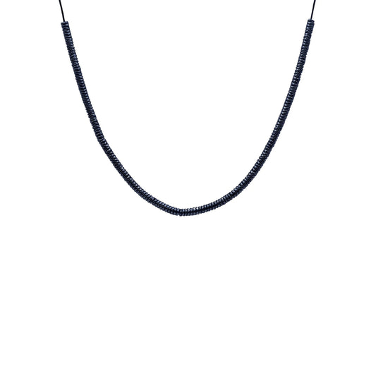 Close-up of Midnight Hematite Sliding Knot Necklace by Camins, featuring dark hematite beads on a black silk cord—handmade in Bali with minimalist, boho-chic elegance.