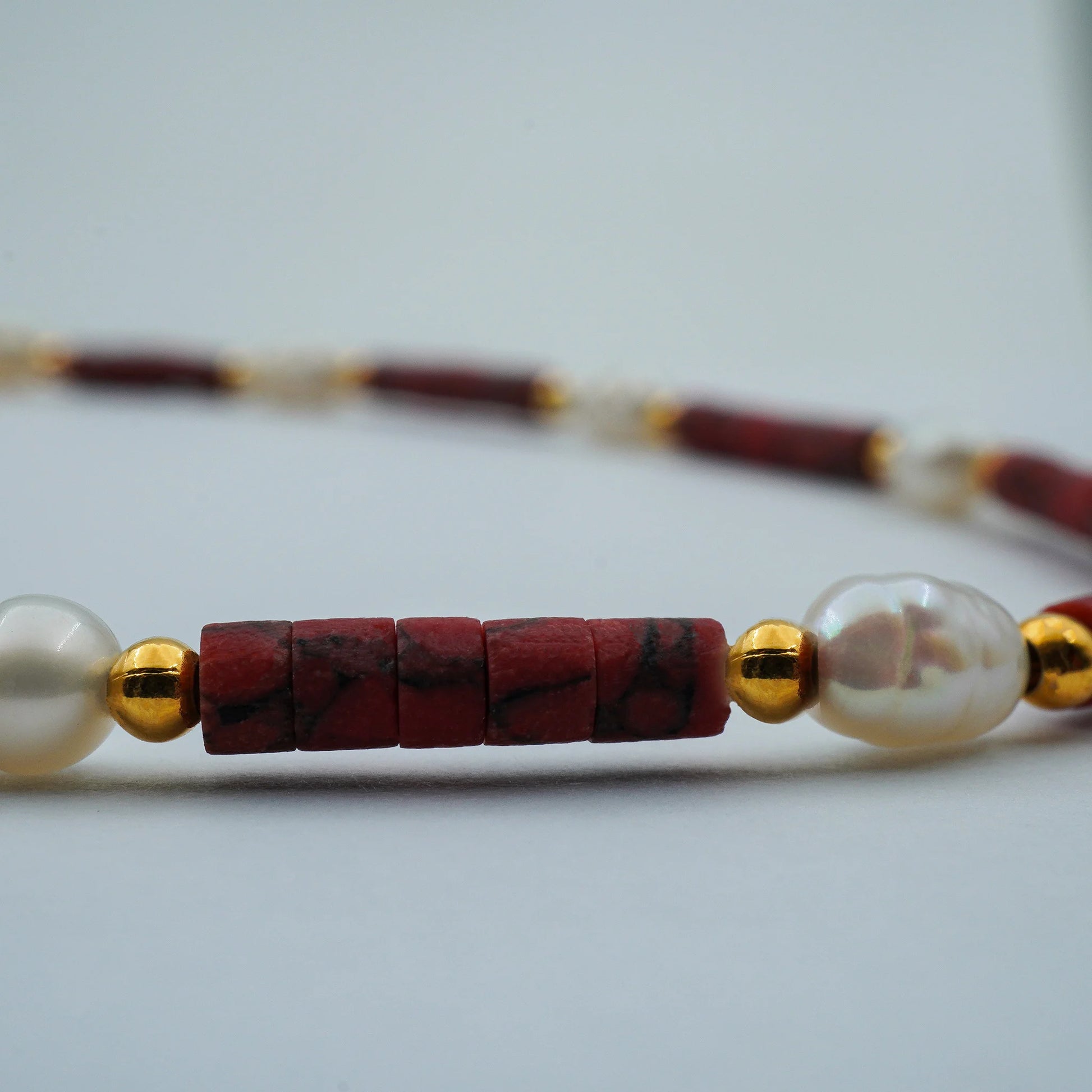 Close-up of the Crimson Pearl Anklet, highlighting rich crimson pearl textures and fine bead details, showcasing handmade Balinese craftsmanship.