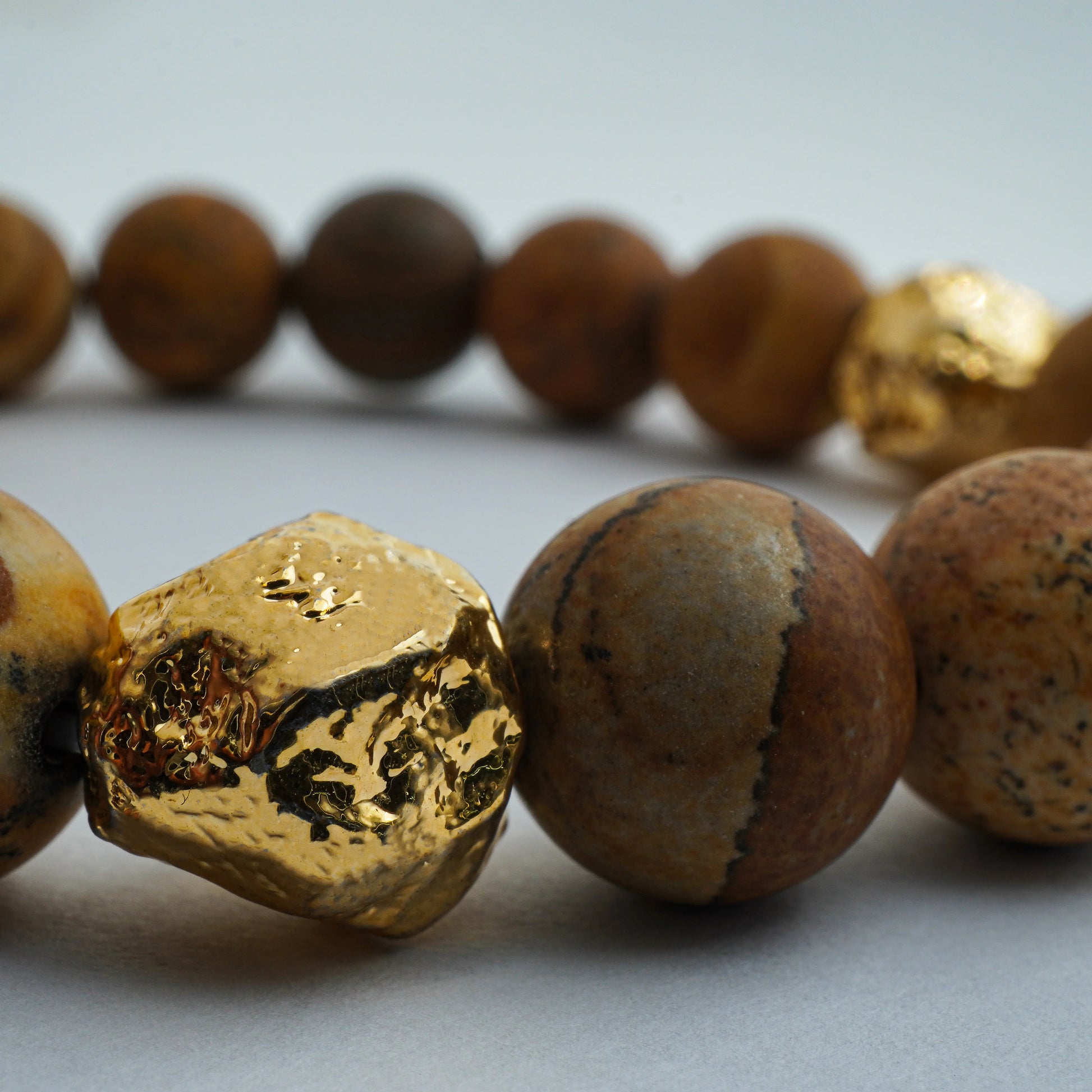 Close-up of Earthstone Jasper bracelet showcasing natural jasper beads and golden accents, highlighting its earthy texture and handcrafted detail.
