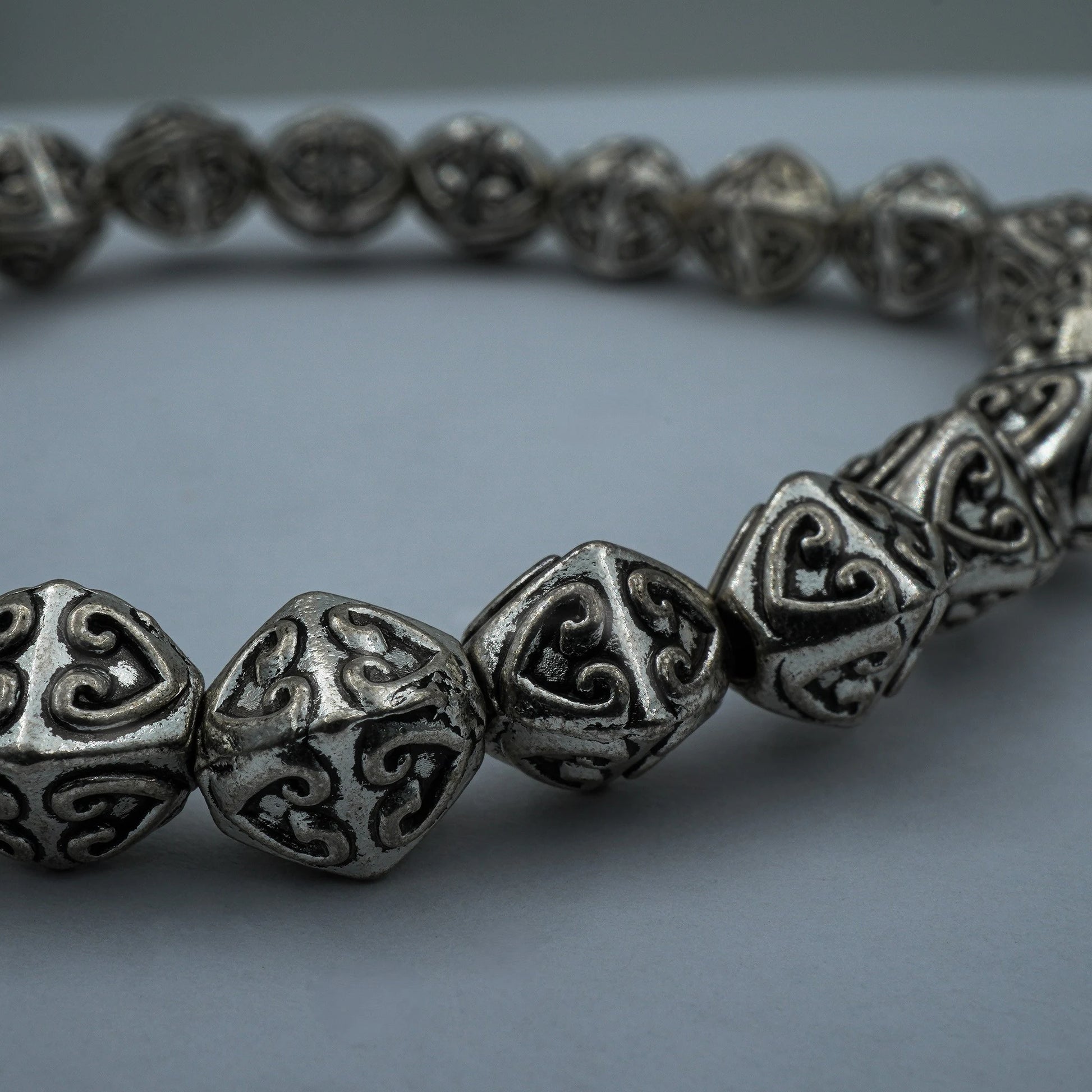 Close-up of the Enchanted Hearts Bracelet, highlighting intricate silver heart charms in a romantic boho design, handmade in Bali.