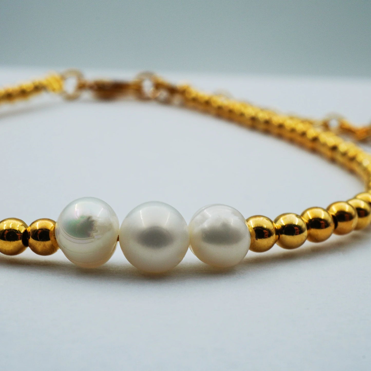 Close-up of the Golden Grace Pearl Bracelet highlighting smooth lustrous pearls paired with golden accents. Handmade in Bali, showcasing refined minimalist elegance with artisanal detail.