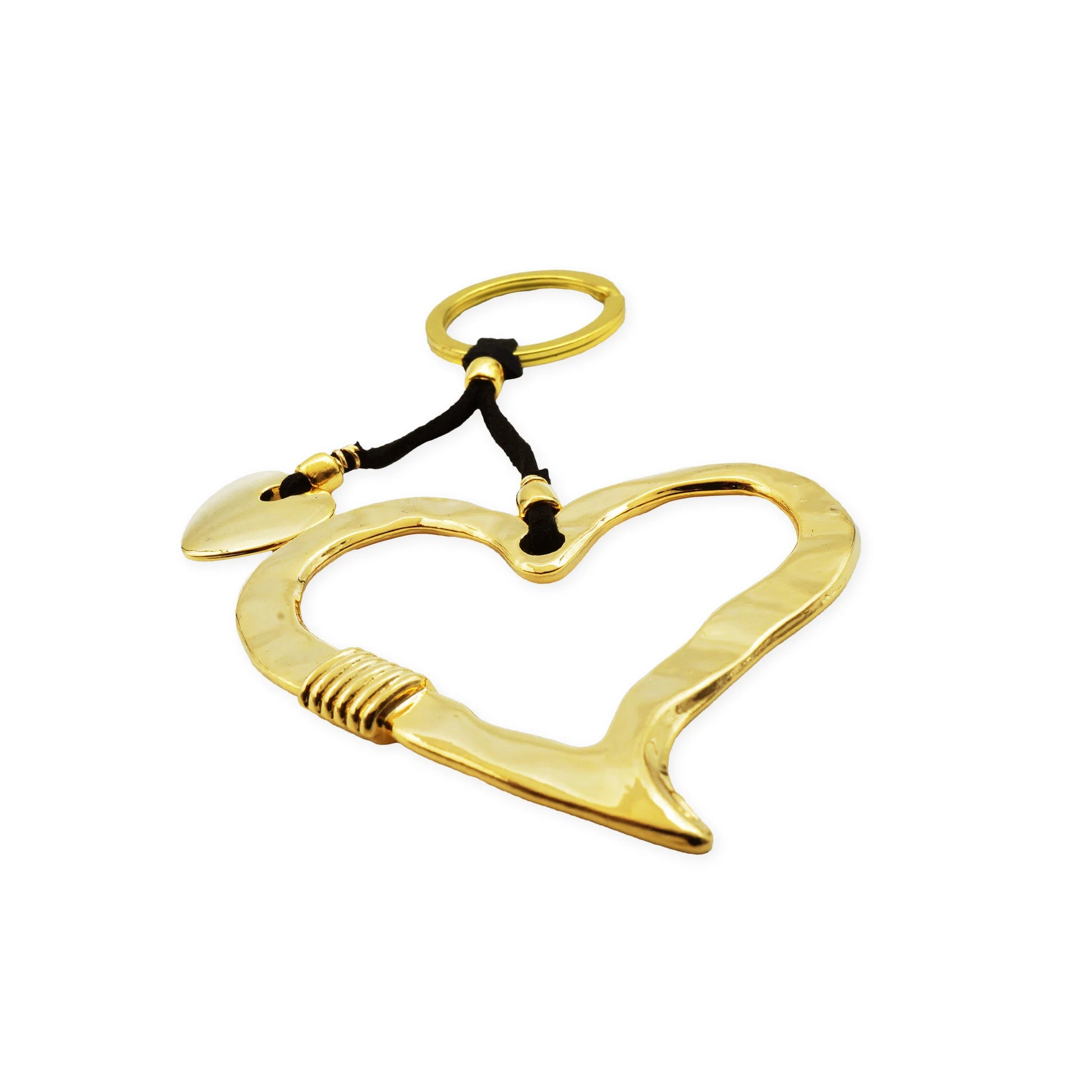 Close-up of a golden heart frame keychain with two metallic heart charms, styled on a hand against a warm neutral background — symbolizing bold love and handcrafted elegance in minimalist Mediterranean style.