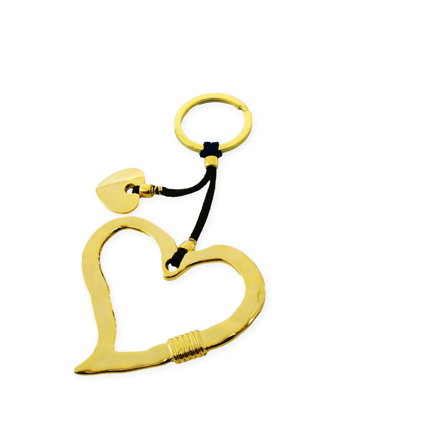 Top view of a golden heart frame keychain featuring two heart charms — one smooth and one textured — lying against a soft neutral surface, reflecting handcrafted charm, bold symbolism, and Mediterranean-inspired detail.