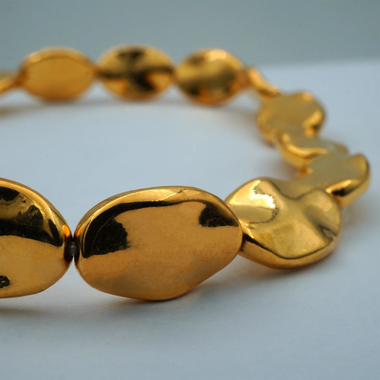 Close-up of the Golden Ripple Stretch Bracelet showcasing polished, sculpted gold-plated beads with artisanal texture, handmade in Bali.