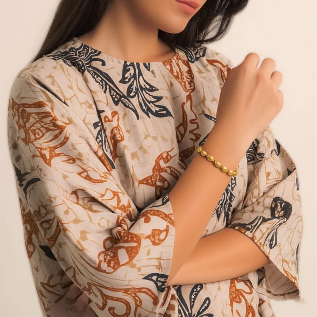 Woman wearing the Golden Textured Bead Bracelet, styled with neutral clothing to show its handmade elegance from Bali