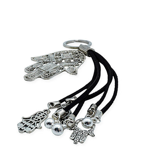 Close-up of Mystic Hamsa Charm Keychain in ancient silver finish with intricate boho details and dangling charms, handmade with black cord for a vintage-inspired spiritual accent – front view.