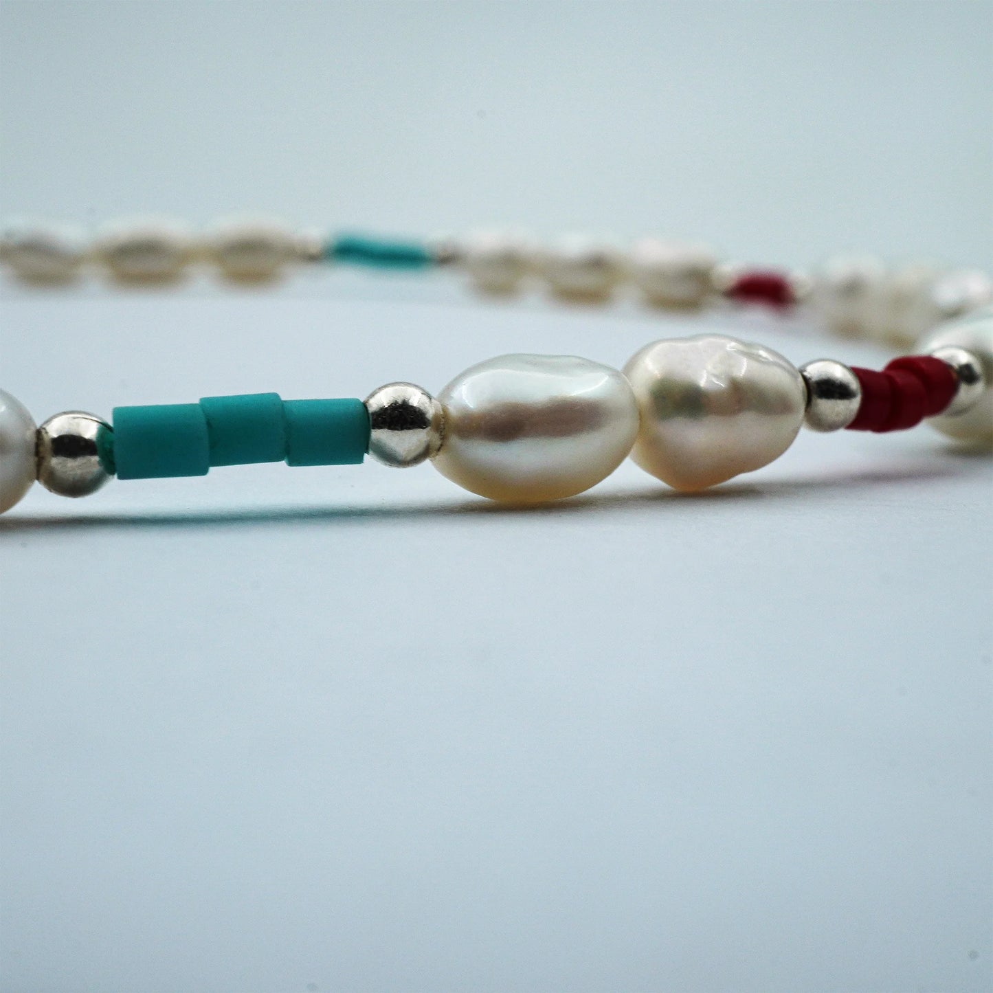 Close-up of Sea Breeze Pearl Anklet handmade in Bali, featuring freshwater pearls and alternating Miyuki beads, highlighting fine artisanal detail on a white background.