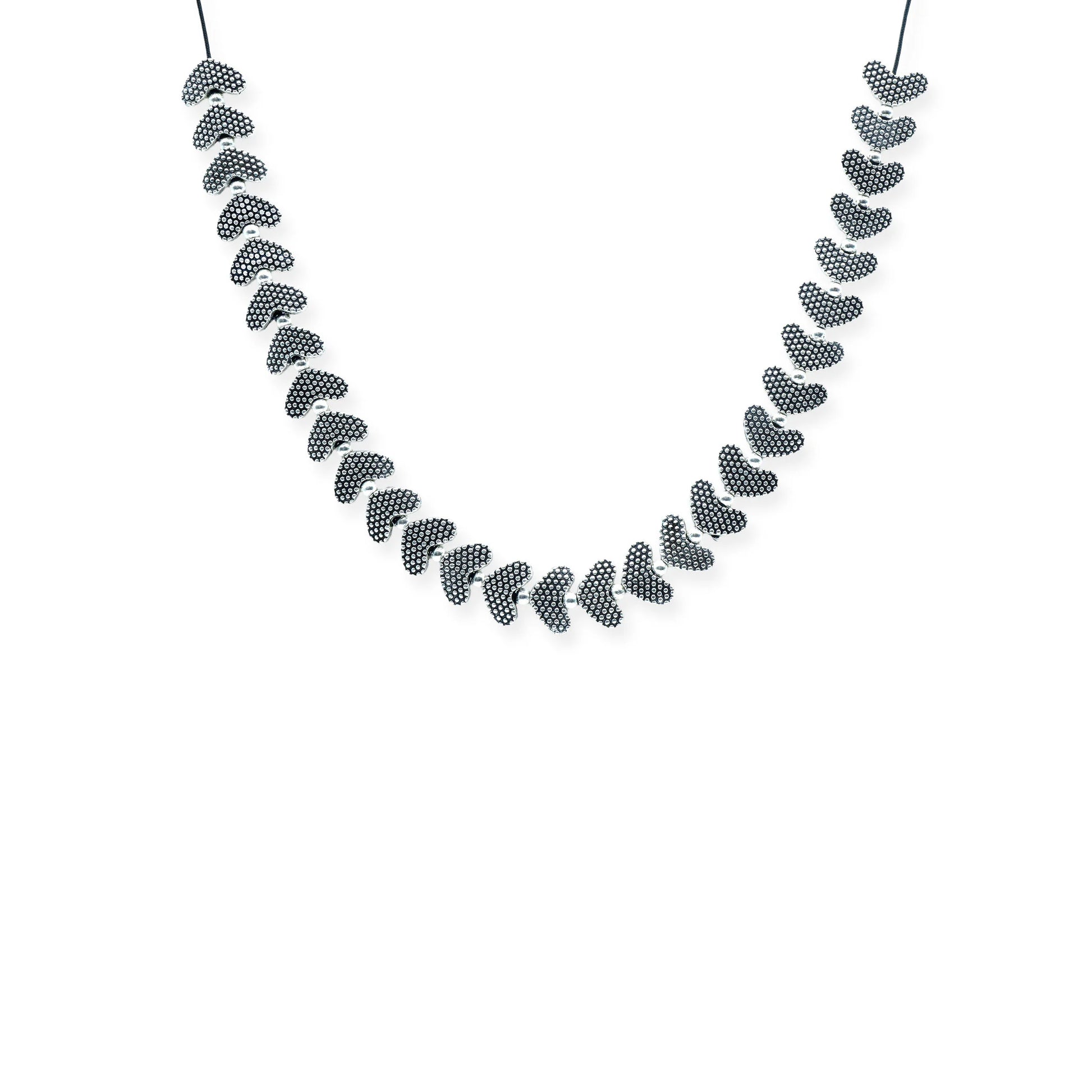 Front view of the Silver Heartbeat Sliding Necklace, featuring silver-plated textured heart beads on a black silk cord, handmade in Bali.
