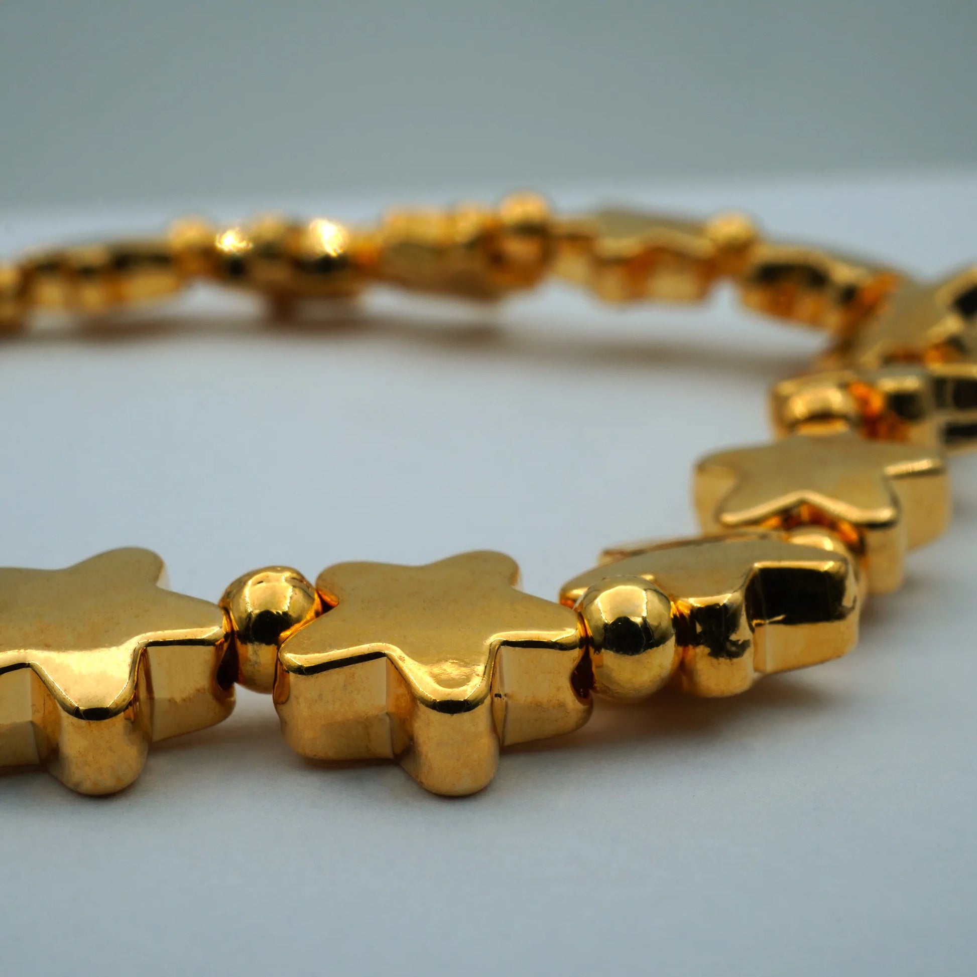 Close-up of gold star-shaped beads on the Starlight Glow Bracelet, handmade in Bali with celestial charm